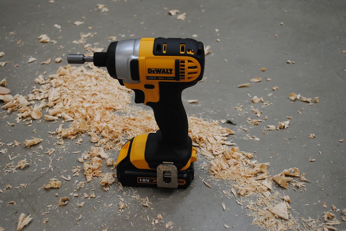 A yellow DeWalt impact driver with a battery pack attached.