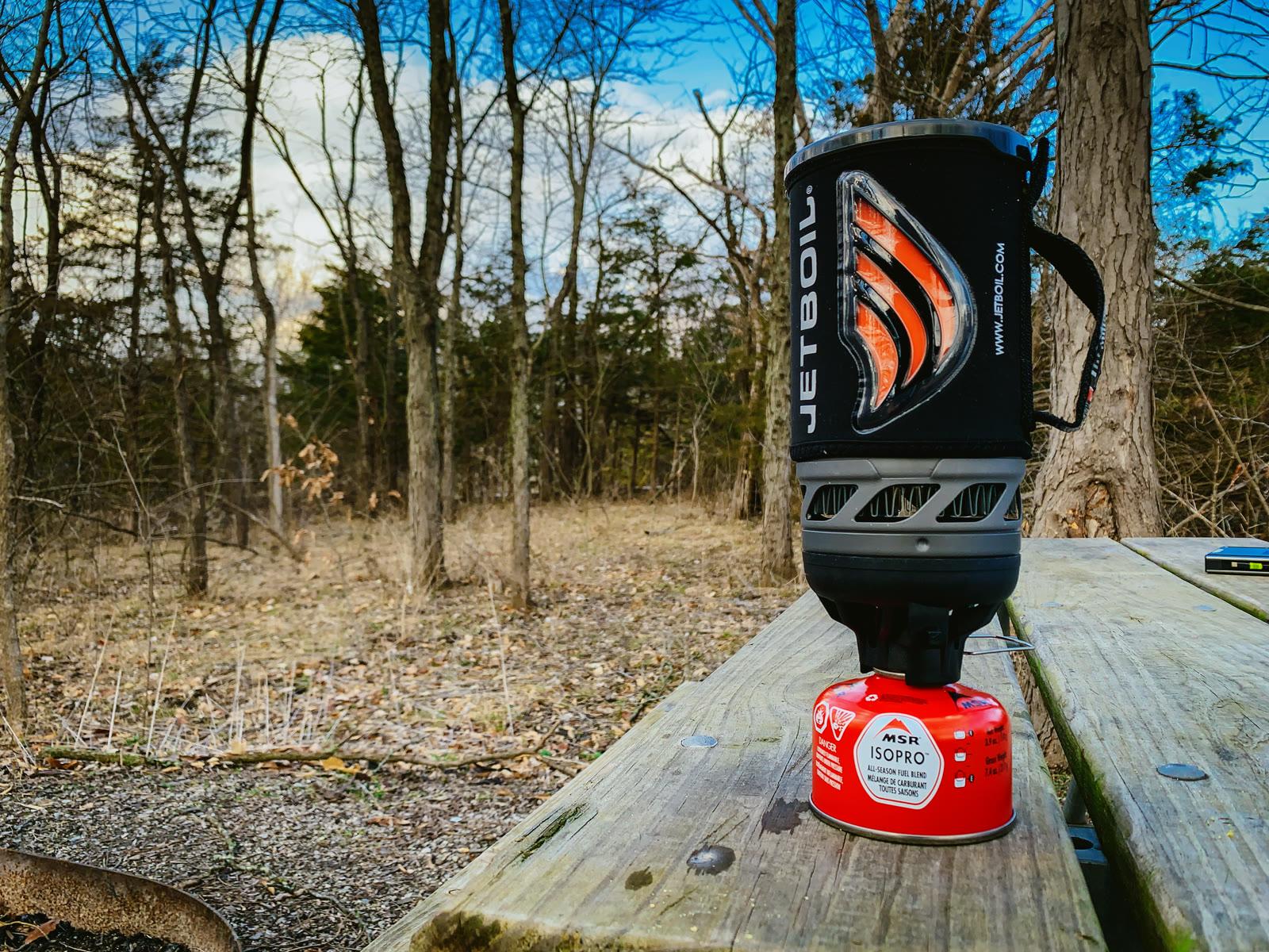 A Jetboil camp stove standing beside a fuel canister.