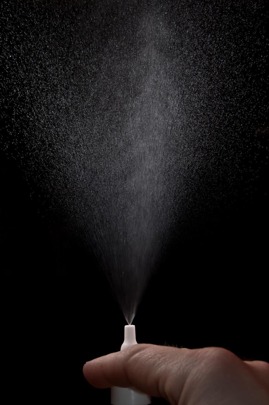 A person using a saline nasal spray.